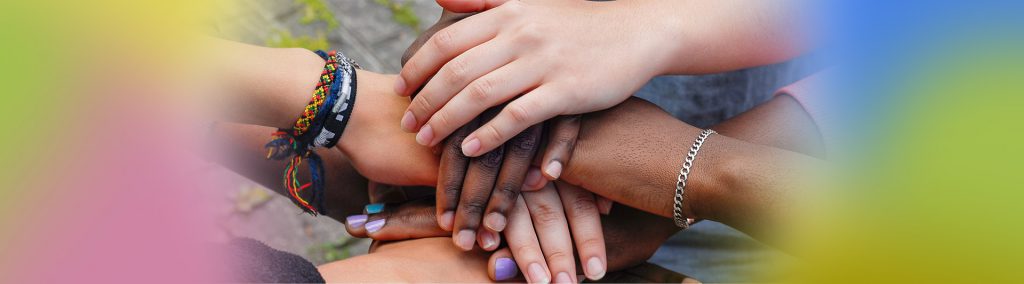 Photo of pairs of hands from 3 people overlapping on top of each other.